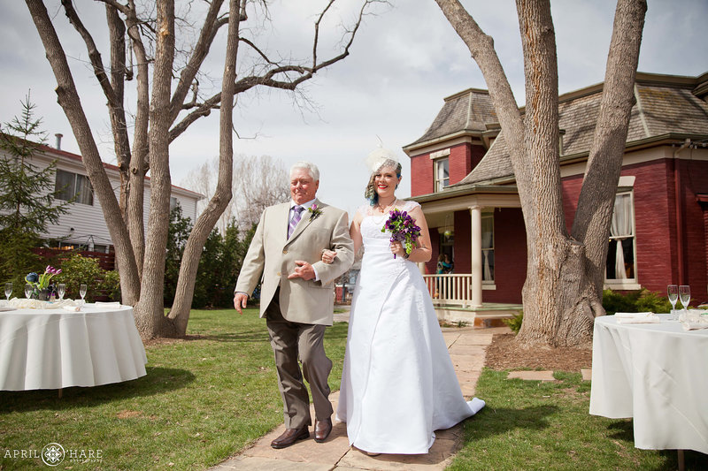 Bride walks down aisle in the backyard of the McCreery House in Loveland Colorado