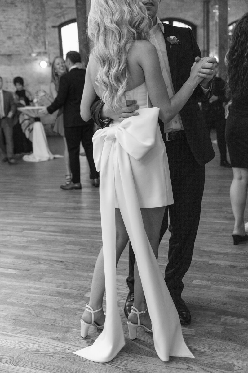 black and white photo of bride's dress on checkerboard dance floor