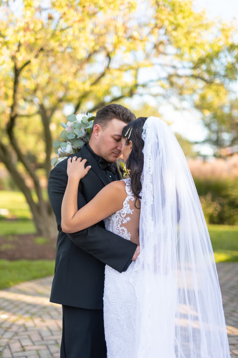 Groom embraces his bride forehead to forehead on their wedding day