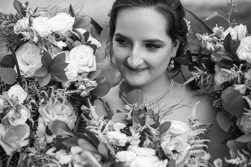 Close up photo of bride surrounded by bridesmaids bouquets