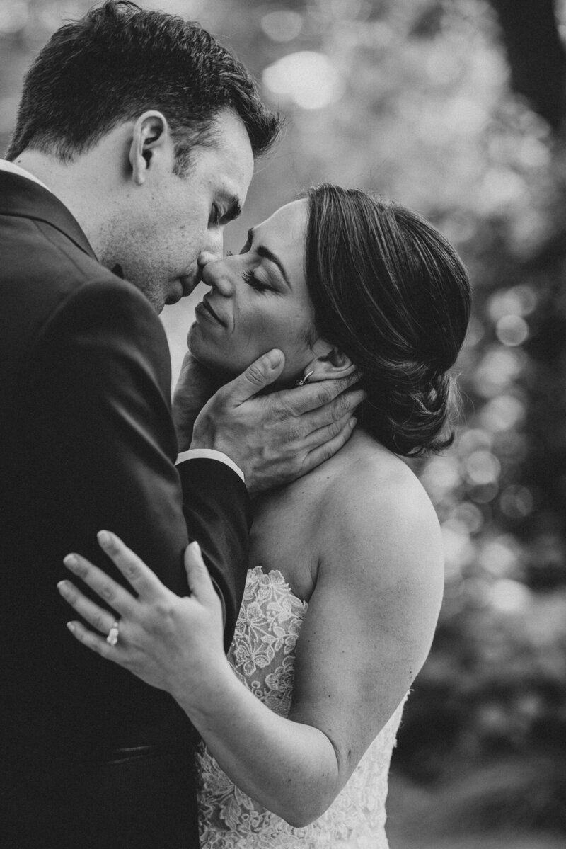 bride and groom kissing in black and white portrait