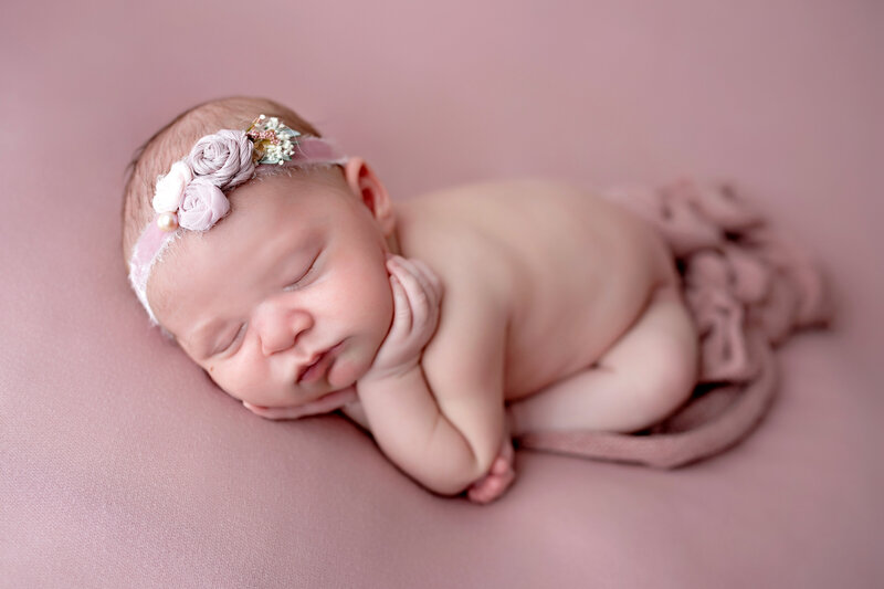 Newborn baby girl posed in lazy froggy position during Jersey Shore newborn photo session.