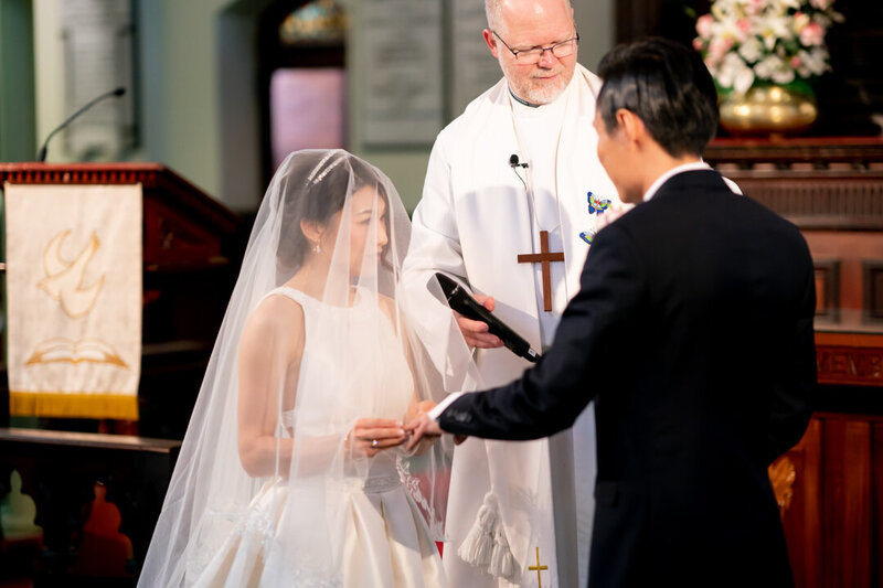 Bride places the groom's ring on the altar