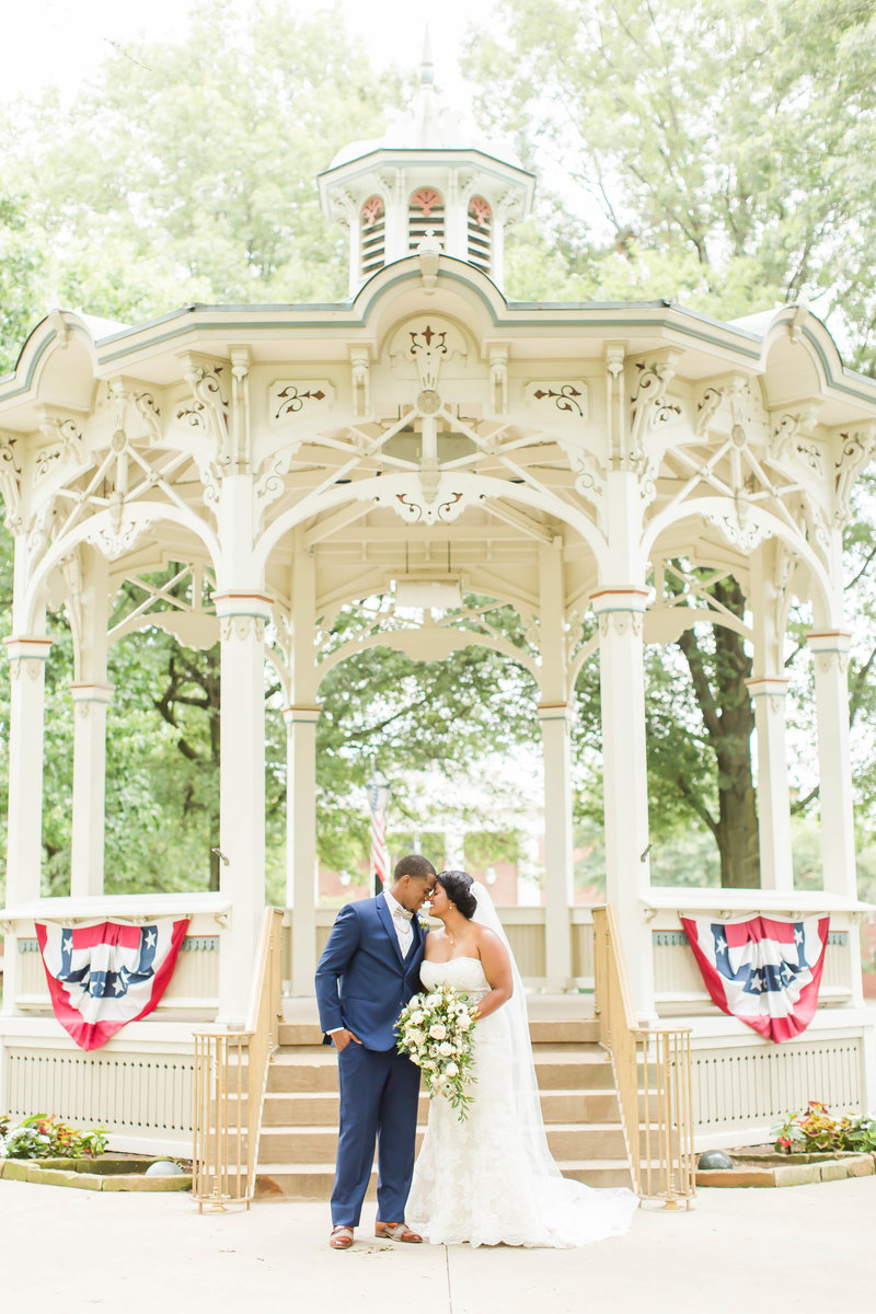 Bride and Groom standing in front of floral arch at Purcell Mansion in Ohio photographed by akron ohio wedding photographer