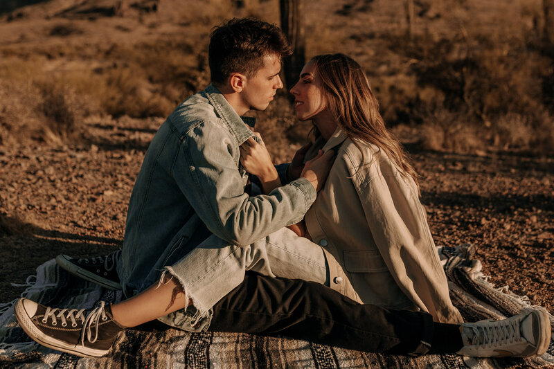 couple session with a blanket kissing wearing converse and levis outfit inspiration for the desert