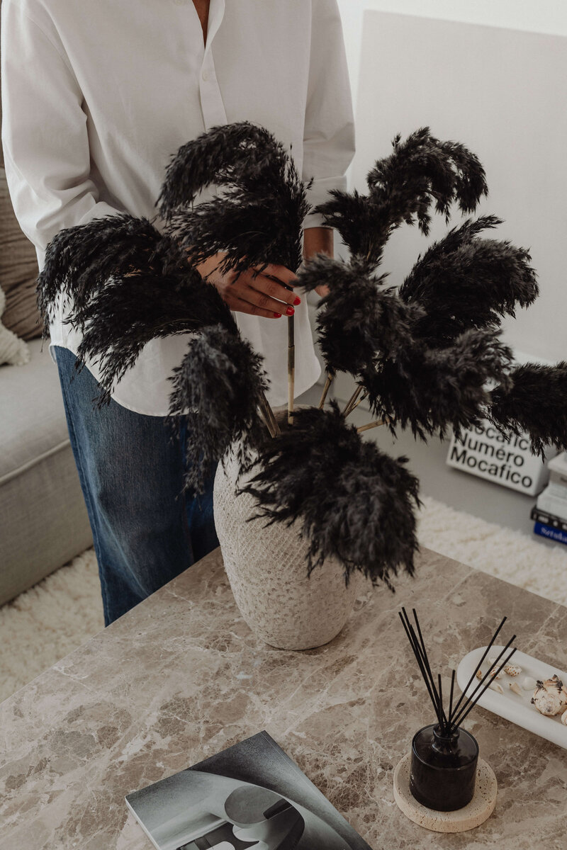 Tami Luger Real Estate |  feathers being arranged in vase on marble table