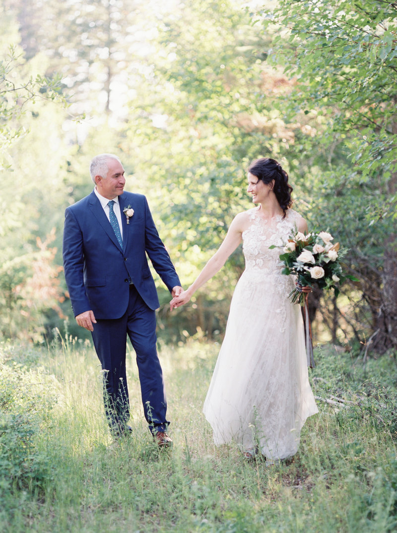 bride and groom walking in woods