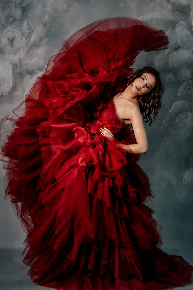 Red prom dress for senior portrait session in studio Lansing Michigan