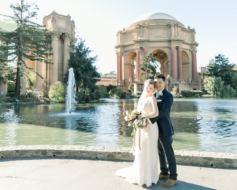 Groom holds Bride as they stand in front of Palace of Fine Arts