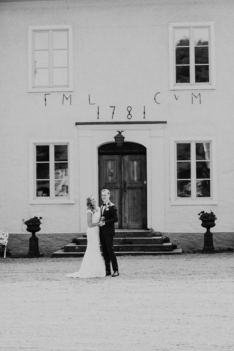 Bride and groom pose for portrait in front of historic Swedish building