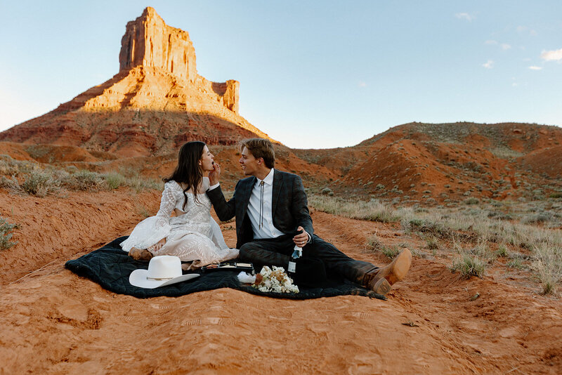 A couple having a picnic in Moab at Ida Gulch during their elopement day
