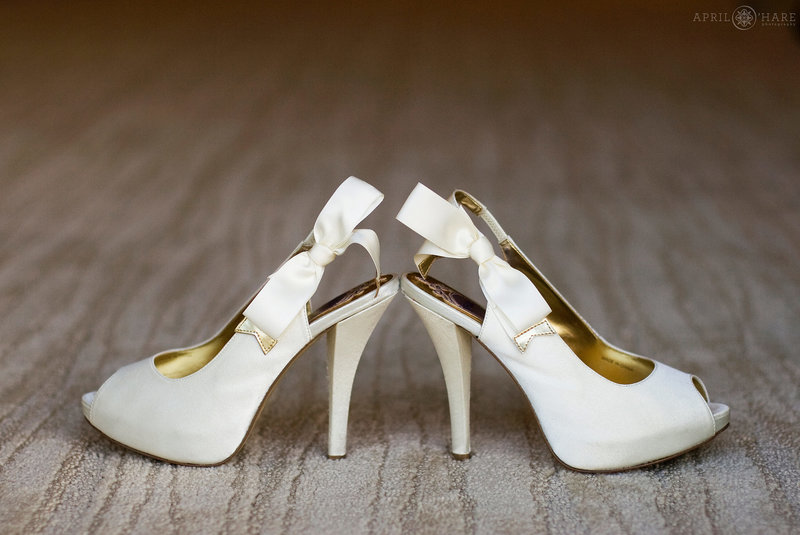 Tall white high heels photographed on the plush carpet at Cielo at Castle Pines getting ready room