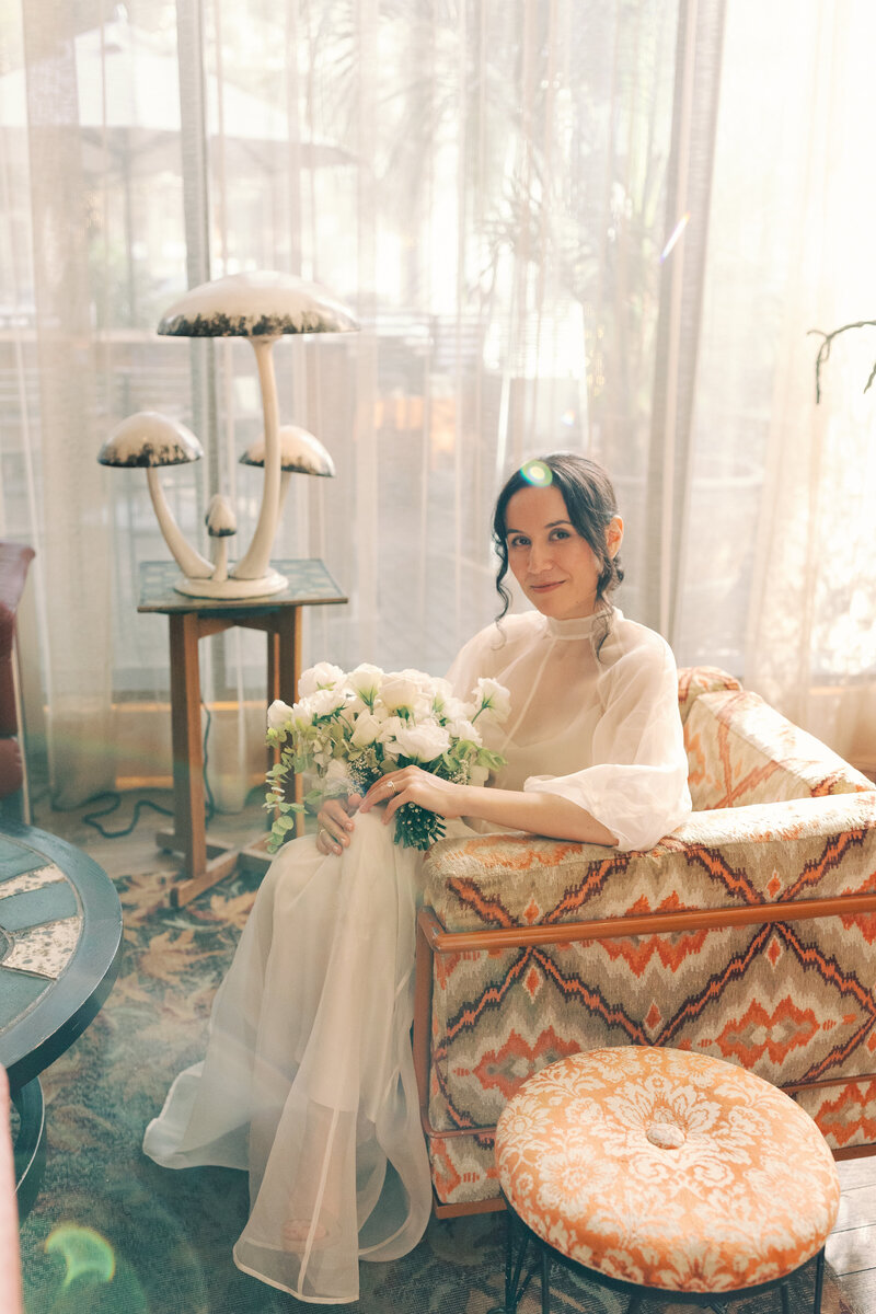 Bride sitting on geometric print couch at proper hotel and Laguna Gloria Intimate Wedding