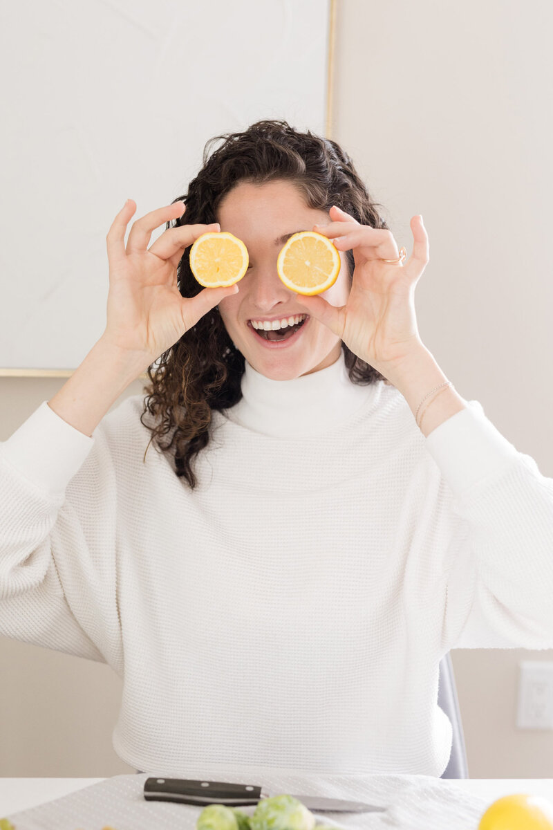 Grace playfully holding two lemon slices over her eyes