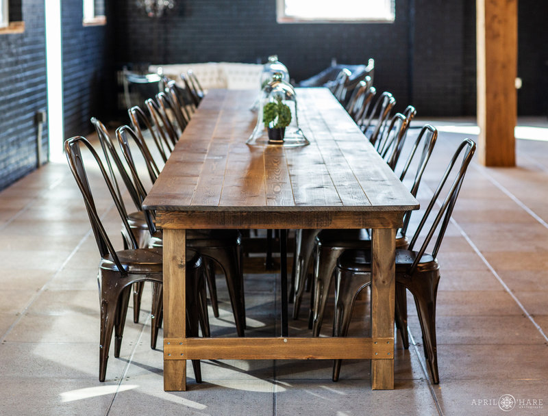 Long wood table with brown metal chairs at Shyft
