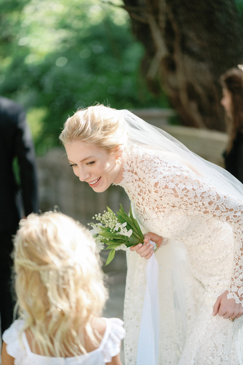 Bride in white holds small bridal bouquet