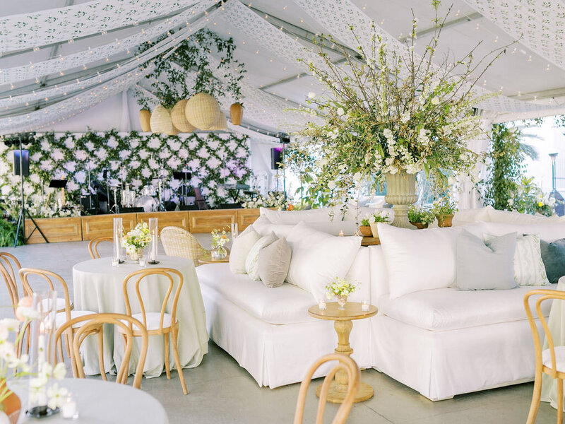 ursuline convent new orleans  tented reception with banquette lounges, greenery trellises, and rattan pendant lights