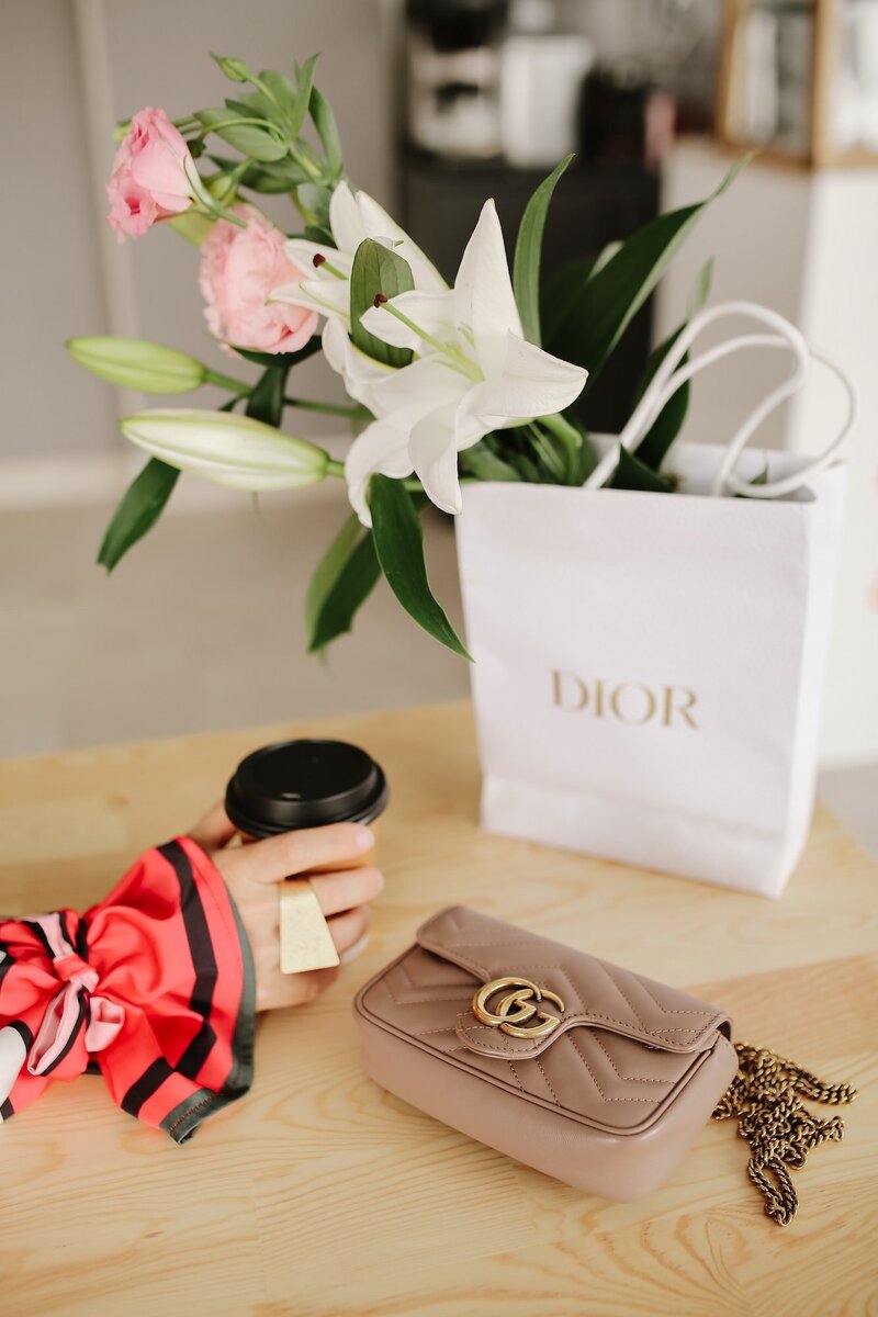 Bouquet of lilies resting in a Dior shopping bag