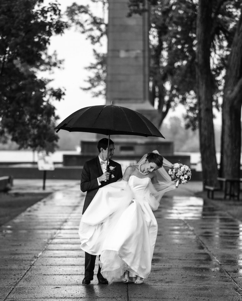 Bride and groom standing under an umbrella in front of Perry Monument at Presque Isle State Park