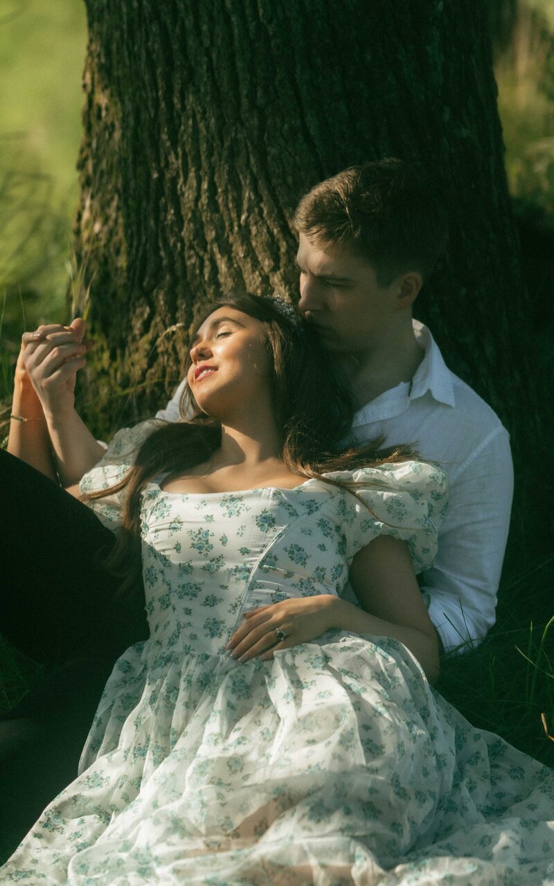 Relaxed couple sitting on the grass, enjoying a peaceful moment together in nature, capturing love and serenity in a calm outdoor setting