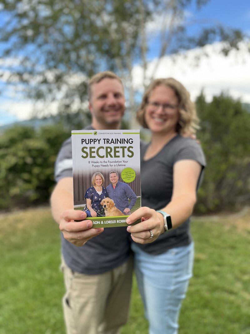 Jason and Lorelei Robbbins, authors of "Puppy Training Secrets" holding out their book
