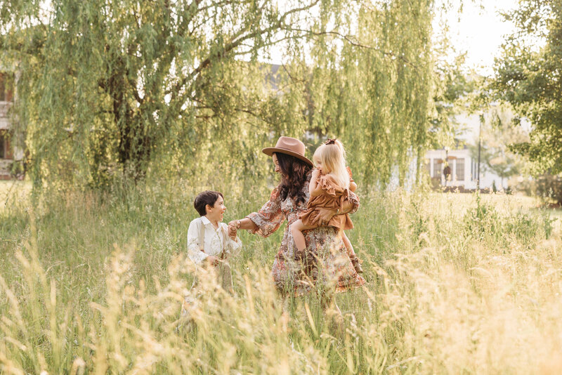 mom with children in grass field