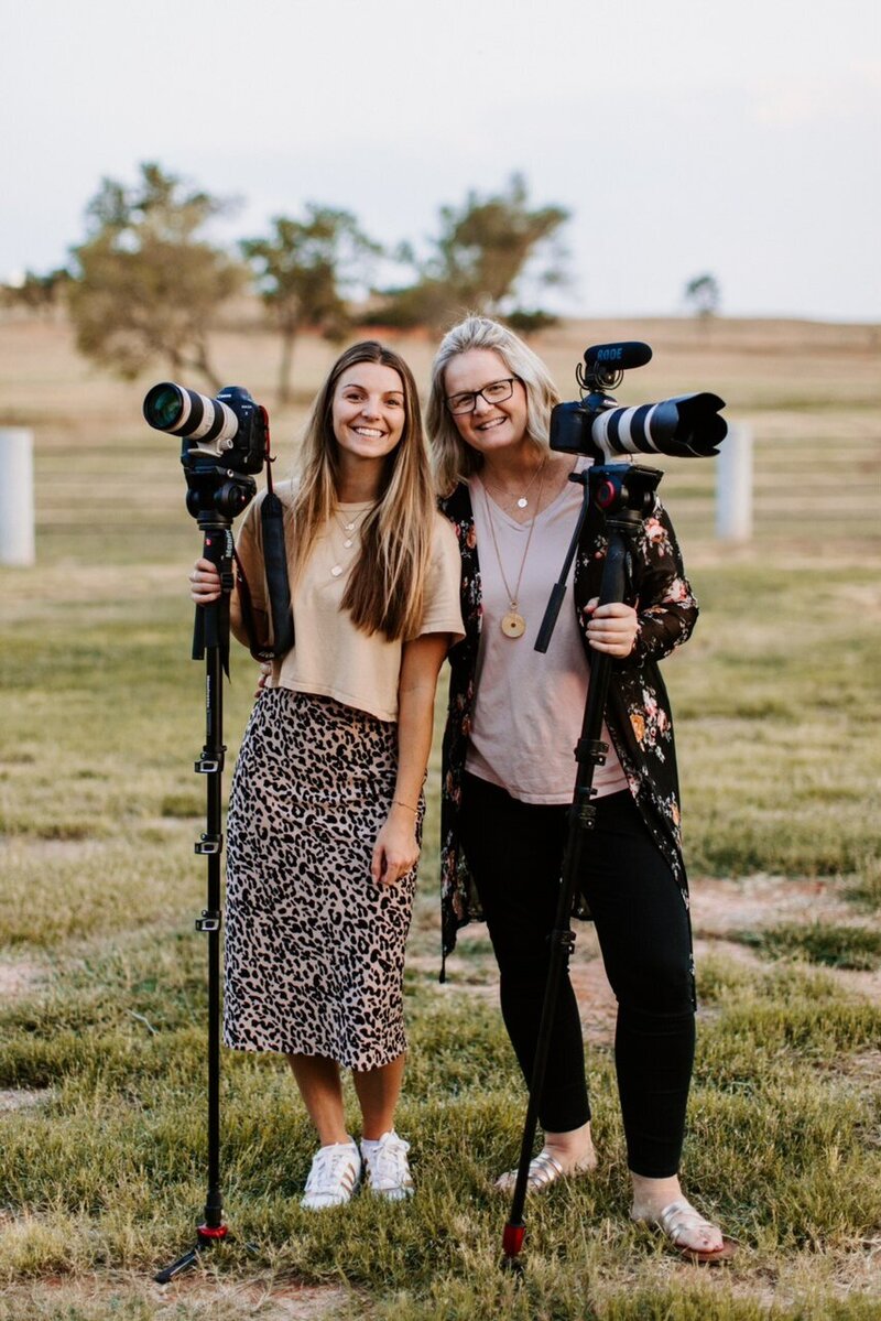 Kaylyn and Dana Pulley holding their cameras smiling at the camera