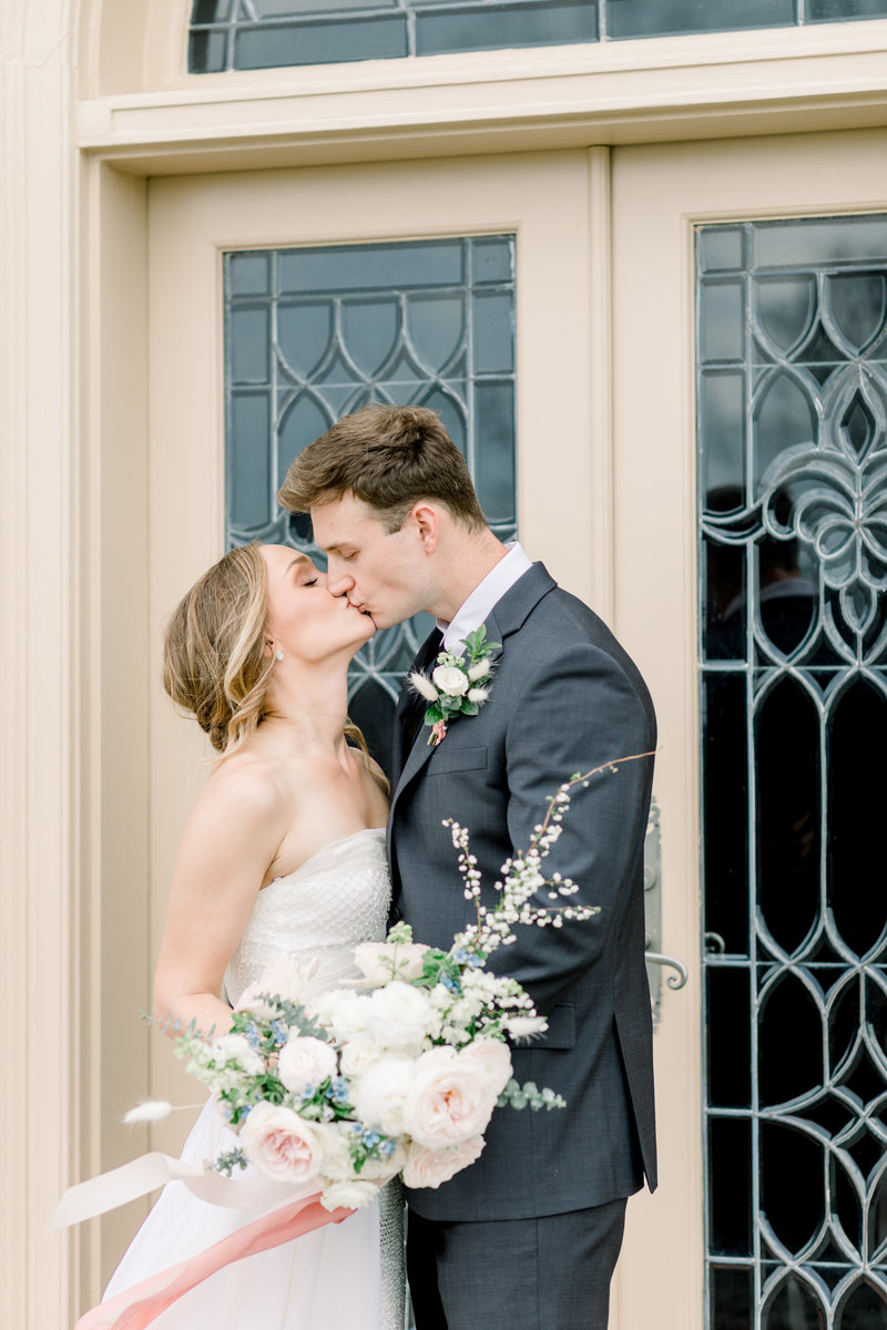 richmond virginia wedding photographer, bride and groom kissing holding wedding florals