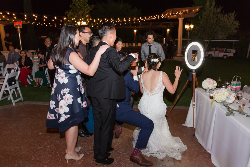 Bride and guests dancing in front of photobooth to make a gif