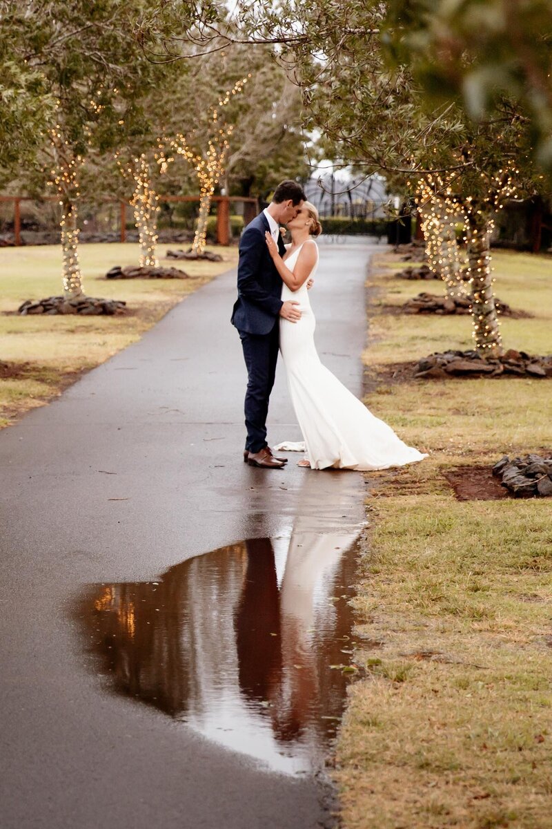 Newly-wed couple kissing on the wet road