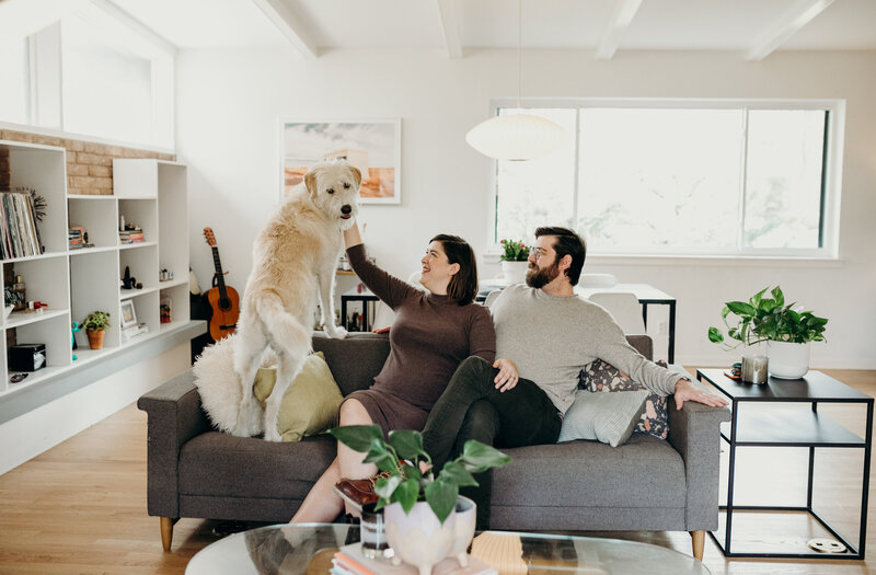 Couple sitting on couch with dog at Austin family photoshoot
