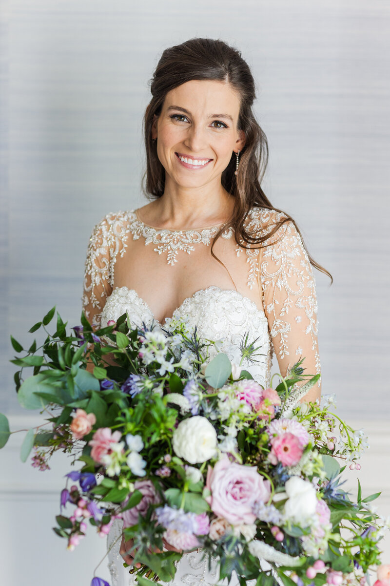 smiling bride holding bountiful bouquet