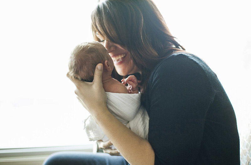 Woman holding baby close and grinning