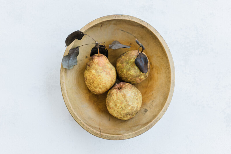 Three pears arranged in a wooden bowl