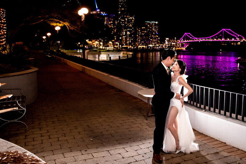 Wedding couple pose with sparkling city lights at Stamford Plaza
