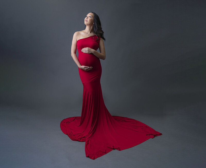 Pregnant women in red dress in studio by Diane Gabriel photography