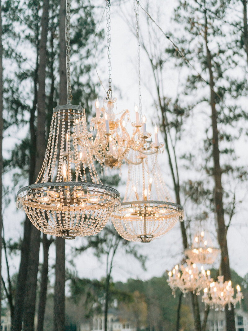 Chandeliers hanging from trees at lakeside wedding ceremony at Ritz Carlton Lake Oconee, Georgia.