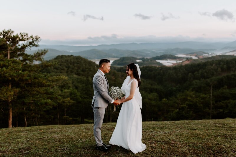A MOUNTAINTOP ELOPEMENT WITH A BRIDE AND GROOM HOLDING HANDS.