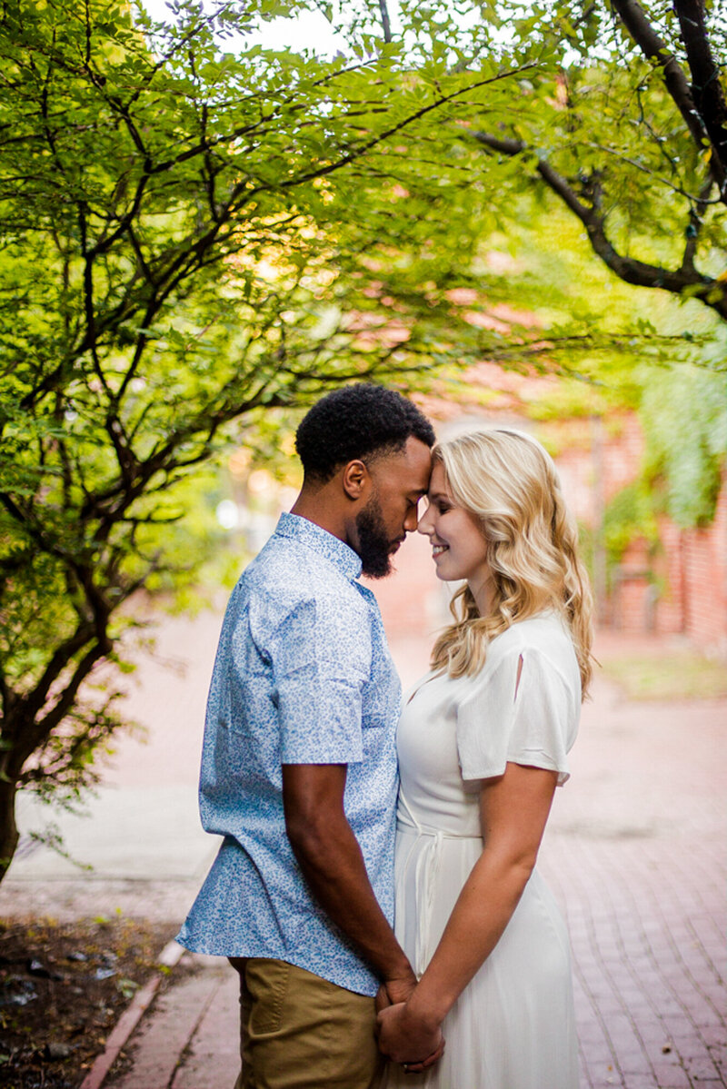 Engaged couple touch foreheads during engagement photos at Modern Tool Square