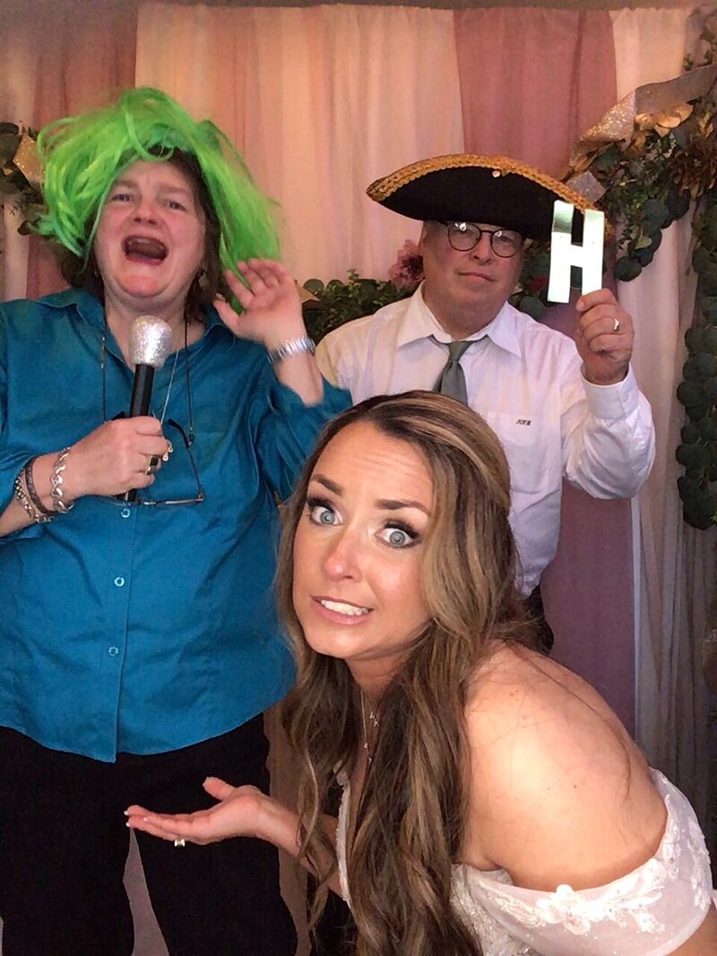 Bride taking funny photos with family in photo booth