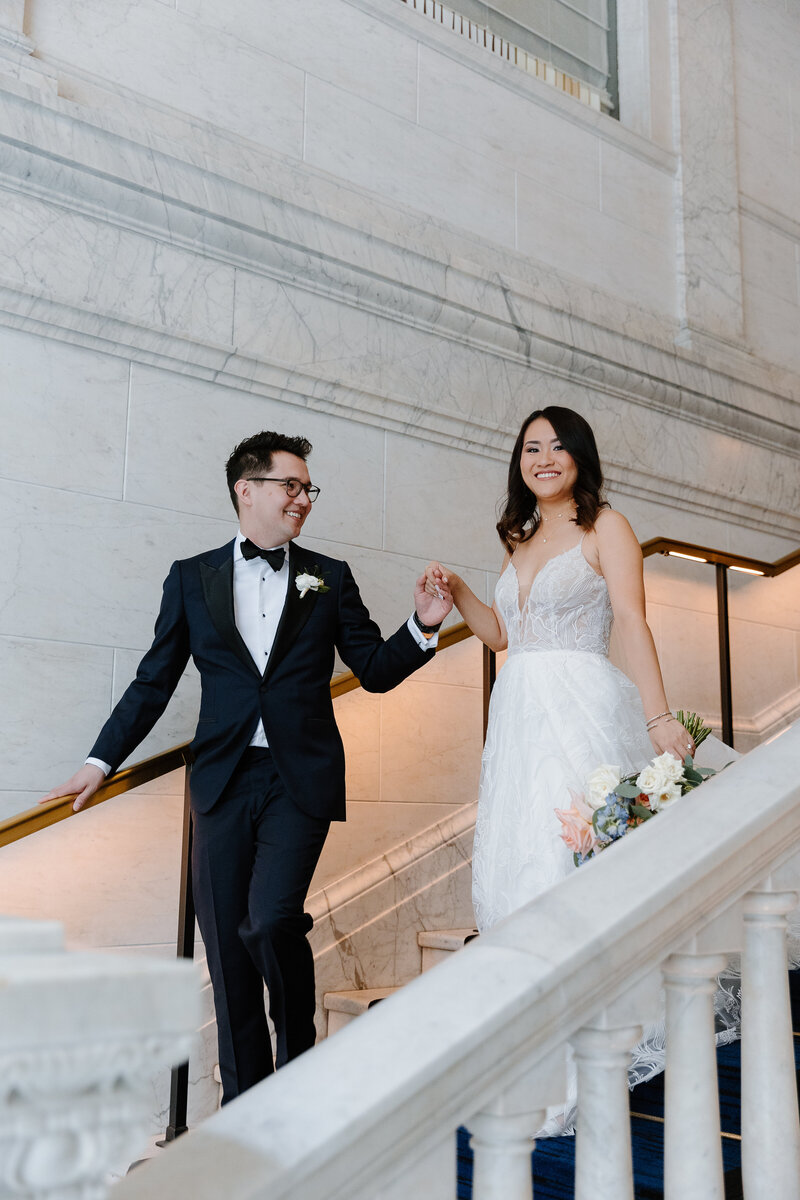 Bride and groom walking down the stairs of the Kimpton Gray Hotel in Chicago