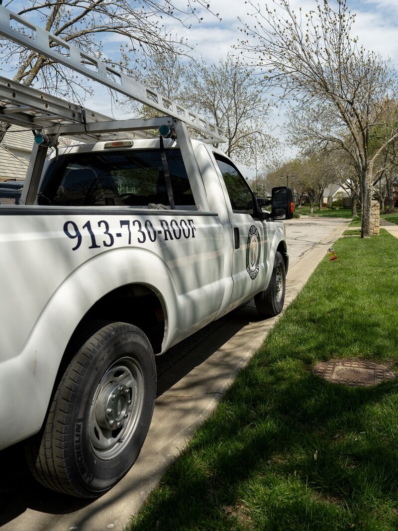 A close up of a Royco Roofing truck with their number 913-730-ROOF on the side