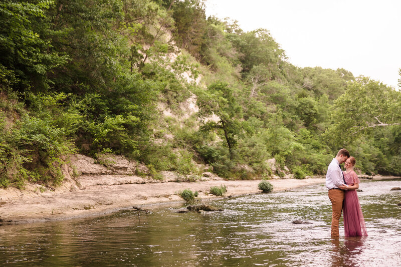 Couple embrace in the river during their engagement session in Austin, Texas. Photo taken by Austin Engagement Photographers, Joanna & Brett Photography