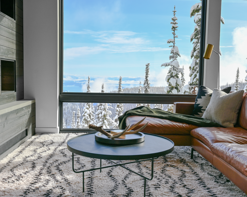 Enjoy winter views of Lake Pend Oreille and the snow-covered landscape from the cozy, modern living room of Mountainside Residence. Floor-to-ceiling windows offer breathtaking vistas.