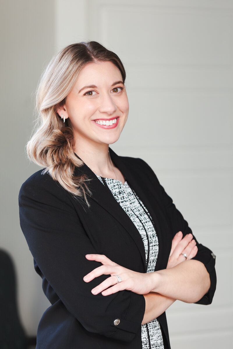 Professional headshot of female attorney Bethany Mulhern, wearing a black blazer with arms crossed