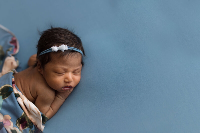 Baby girl on beautiful blue fabric flora wrap studio poses