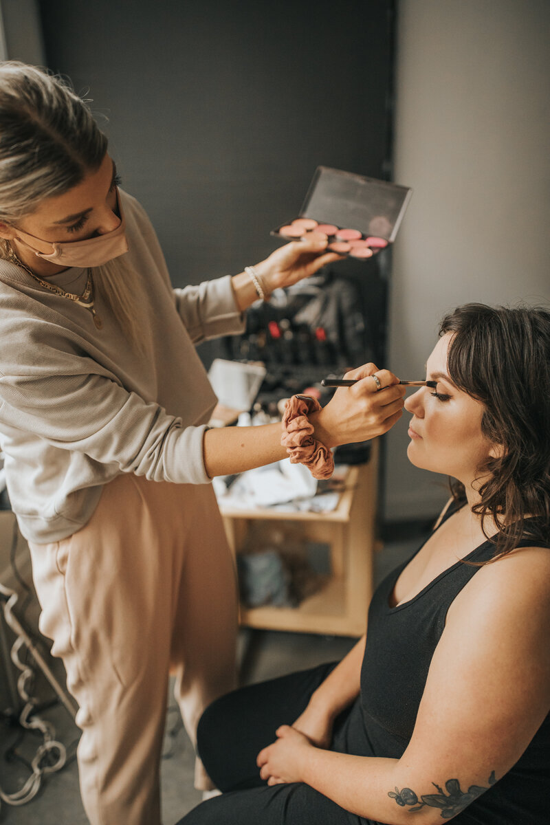 Kahlia Adams makeup artist doing makeup on a client in Boudoir studio in Vancouver BC