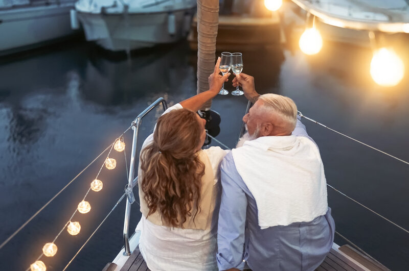 middle age couple drinking champagne on yacht