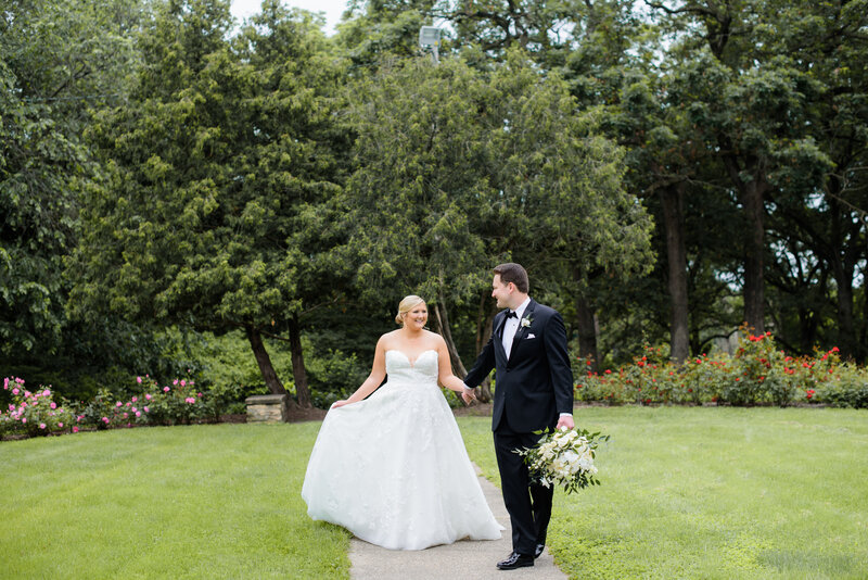 Bride and Groom strolling through a local rose garden