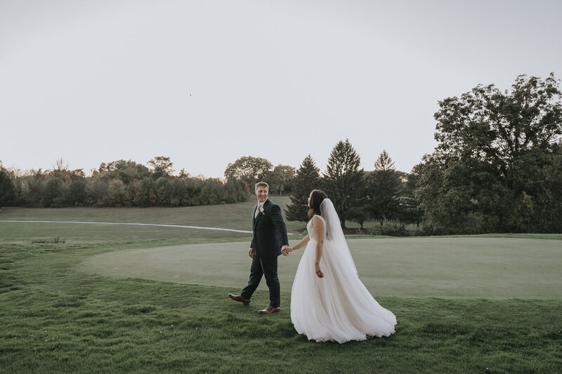 groom and bride walking while holding hands